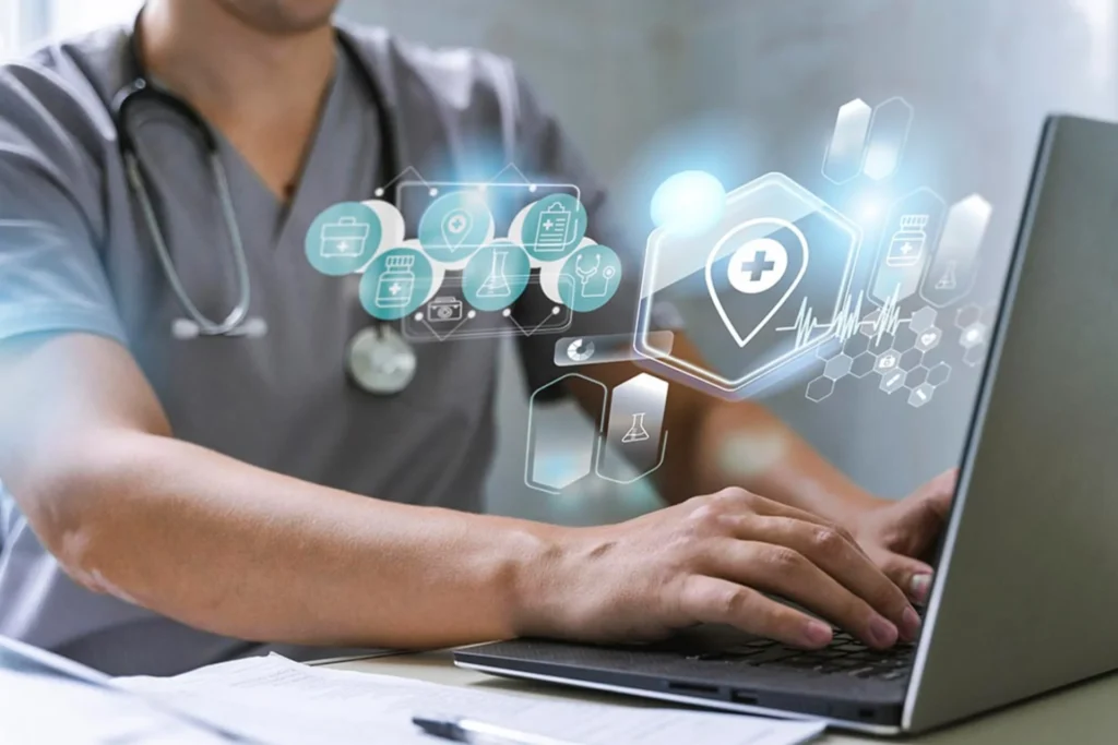 Doctor interacts with a laptop featuring icons, highlighting the role of medical billing in healthcare IT goals